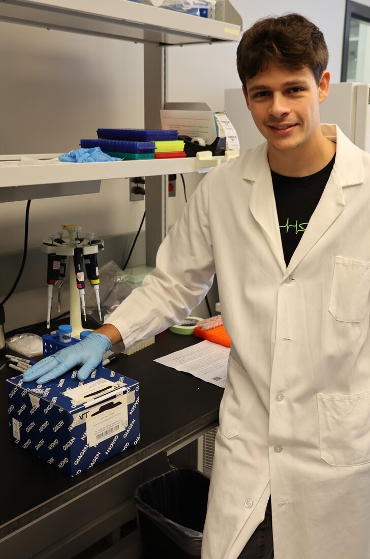 Jeremy in a lab coat at a molecular lab bench